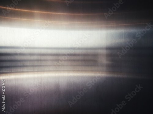 Stainless steel surface with a horizontal light curve.