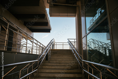 The geometry of the iron railings. Steps overlooking the blue sky.