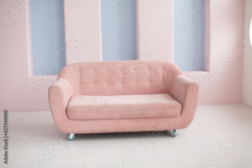 Pink sofa on a pink wall background 