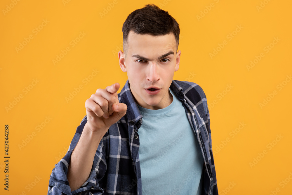 Angry young man pointing finger at you in accusation, saying It's your