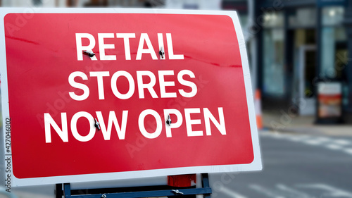 Retail stores now open sign in a city-centre 