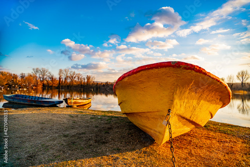 Old yellow boat on the ground by the lake photo