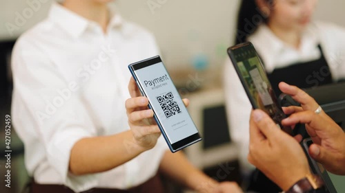 Customer paying with qr code on smartphone screen NFC payment technology at coffee shop.Midsection of female staff showing contactless menu QR code on digital mobile.