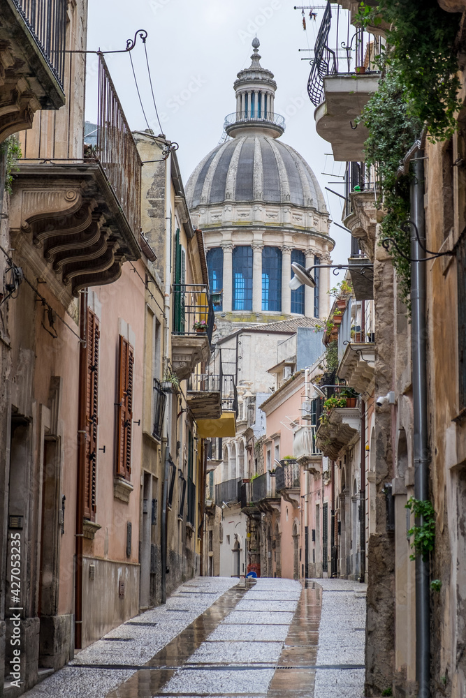 Calles en el casco histórico de Catania con la cúpula dela catedral de fondo en Sicilia, Italia
