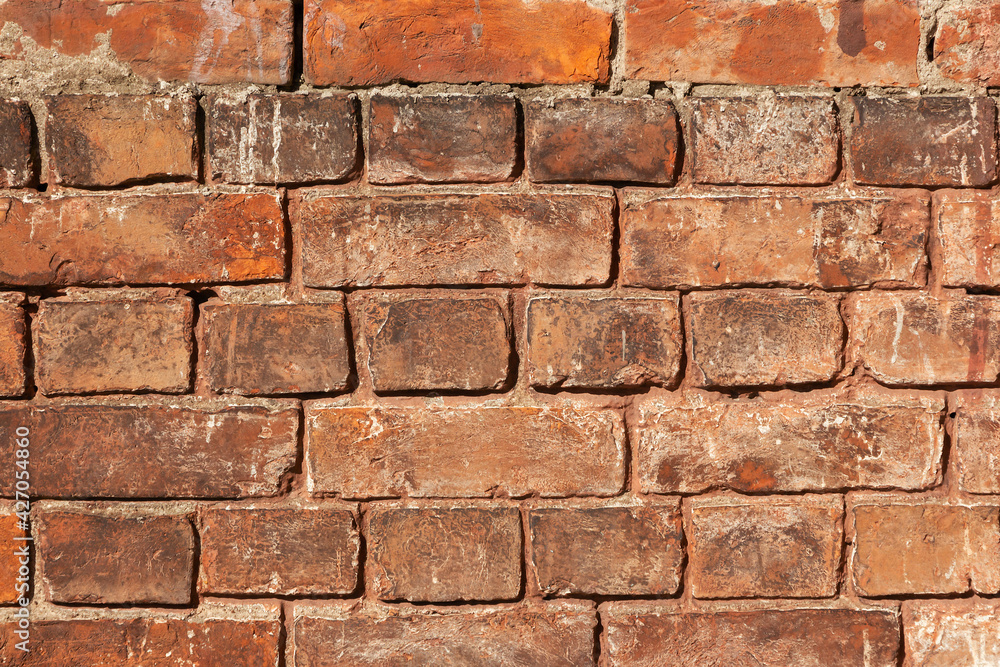 Obraz premium Old brick wall from dark brown and red bricks close-up. Grunge industrial masonry background