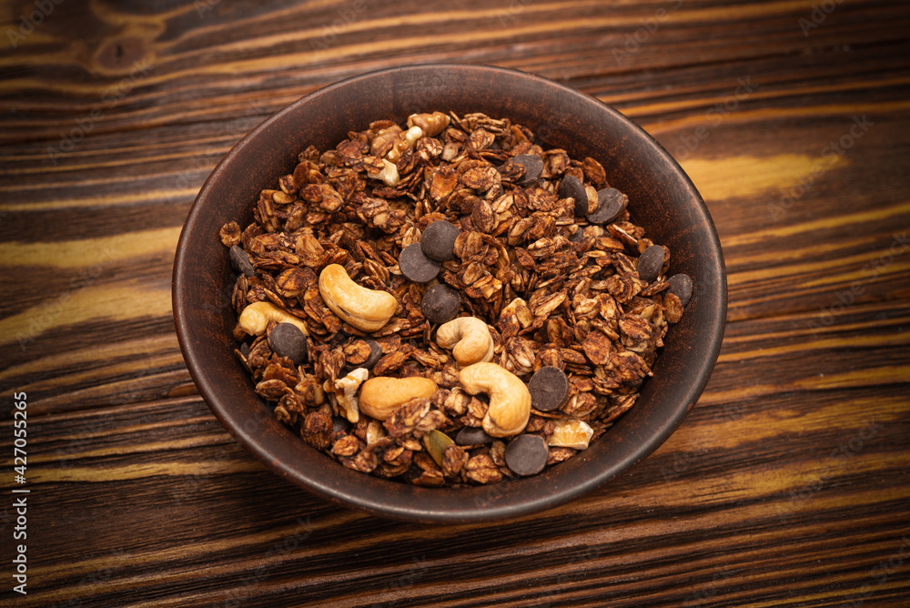 Chocolate granola cereal with nuts in a bowl. Chocolate granola cereal with nuts in a bowl.