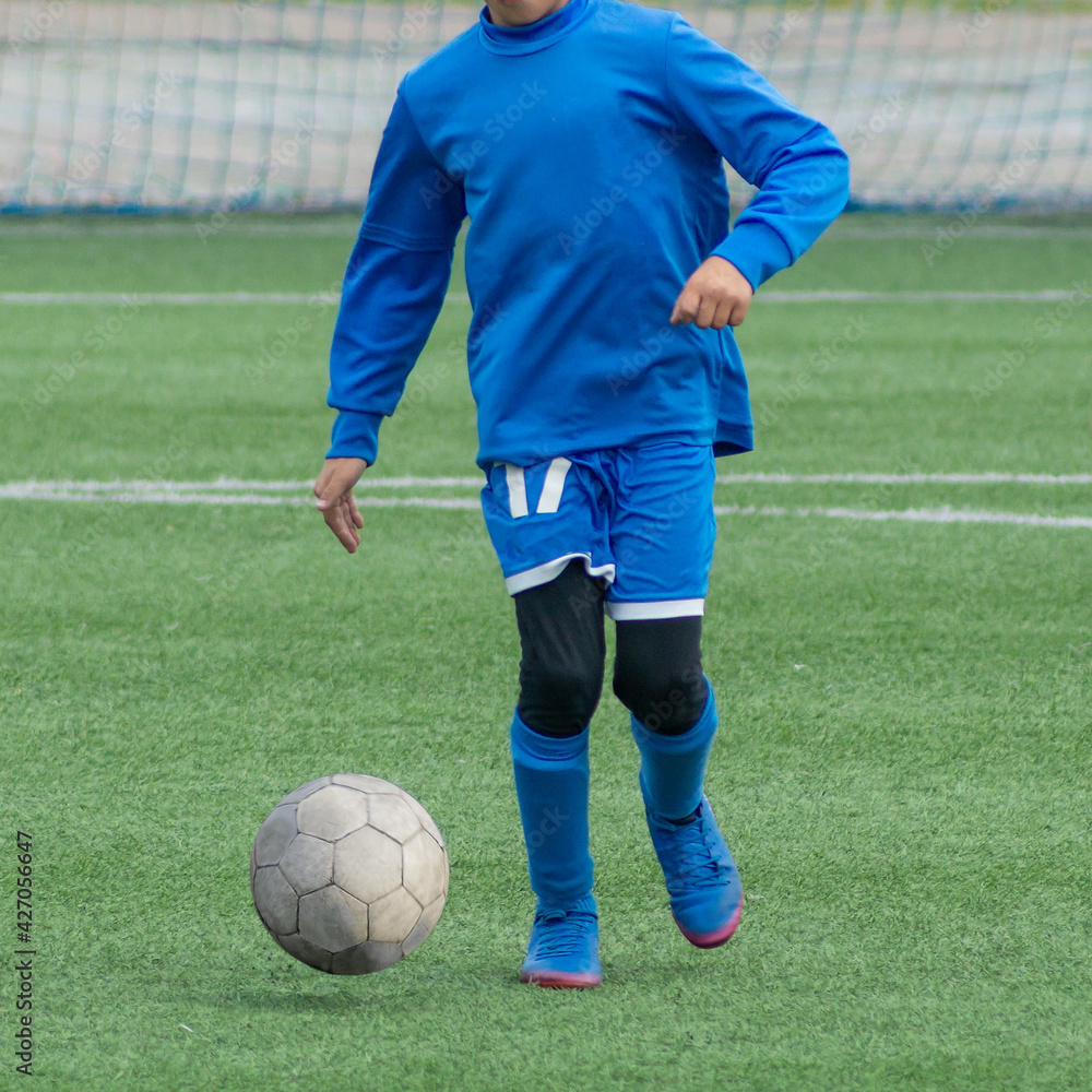Fototapeta premium Children's football. Children are playing football. The active struggle and dynamics of the boys' soccer match. The boys are recklessly fighting for the ball
