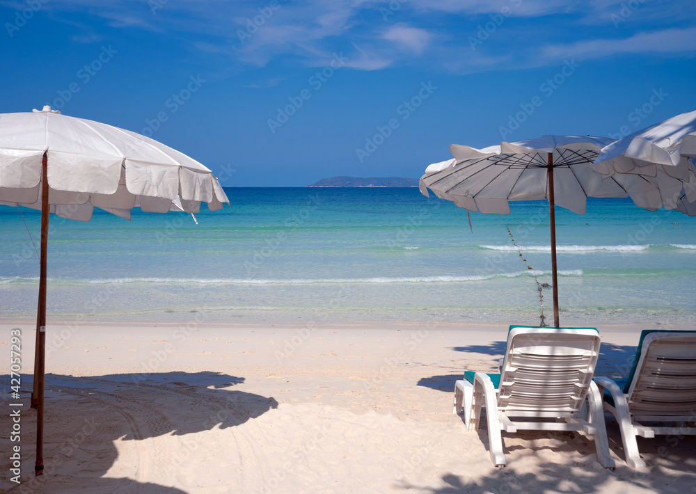 bright blue sea beach with white umbrella and beach chair for relaxing in summer in sunny day, relax and tranquil sand beach at Thian beach, Koh Larn island, travel destination in Chonburi, Thailand 