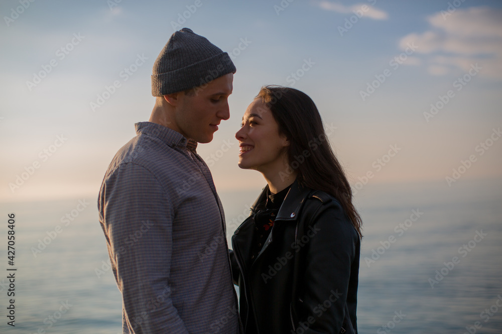 a guy and a girl stand on the beach by the sea looking at each other and smiling. The concept of true love. High quality photo