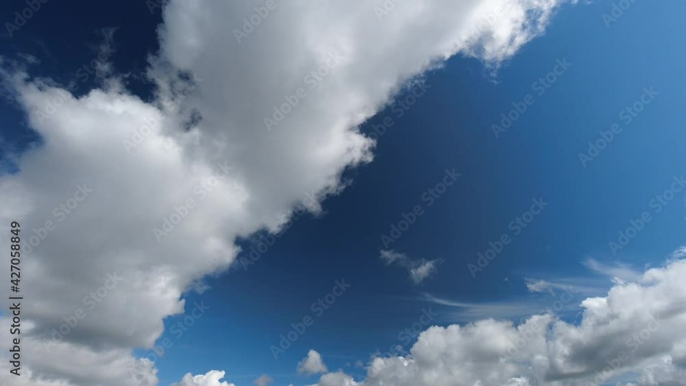 Small puffy clouds roll past on clear Spring day, sky time lapse Small puffy clouds roll past on clear Spring day, sky time lapse