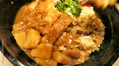 Katsu curry a popular Japanese curry base dish. Eating it with chopstick. photo