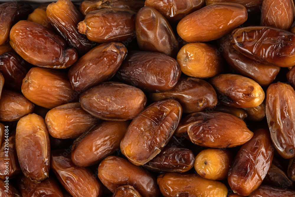 Obraz premium The surface texture of selected dried dates. Natural oriental sweets.