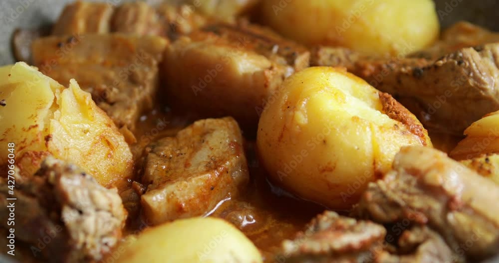 Bacon with potatoes simmering in thick sauce, close up, no people Bacon with potatoes simmering in thick sauce, close up, no people