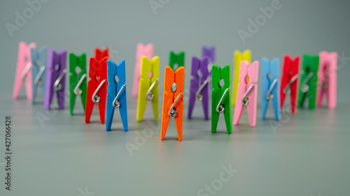 Multi-colored clothespins are in a row on a gray background.