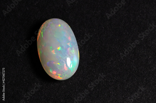 Colorful opal gem on black background