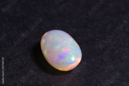 Colorful opal gem on black background