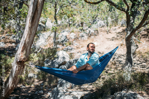 A man in a hammock on a hike in the mountains.