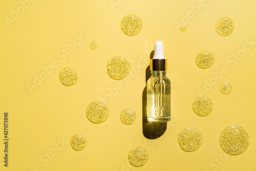 natural cosmetics for face care serum bottle on yellow background, top view