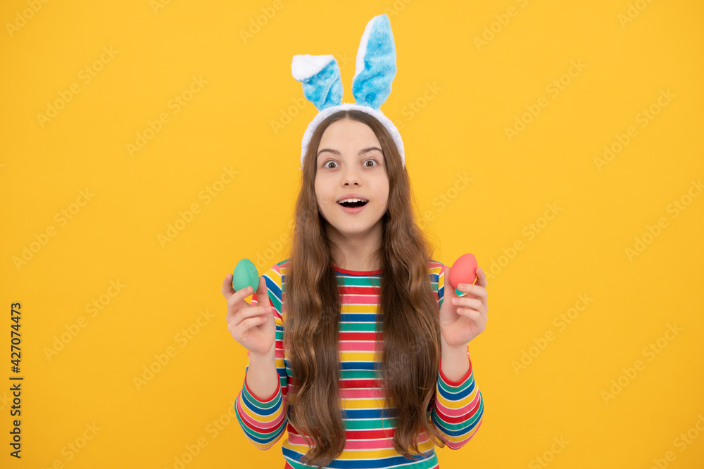 amazed easter teen girl in rabbit bunny ears holding painted eggs for holiday egg hunt, bunny hunt