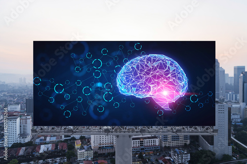 Brain hologram on billboard with Kuala Lumpur cityscape background at sunset. Street advertising poster. Front view. KL is the largest science hub in Malaysia, Asia. Coding and high-tech science.
