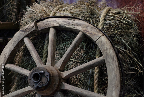 Wooden wheel on hay, rustic style, country background