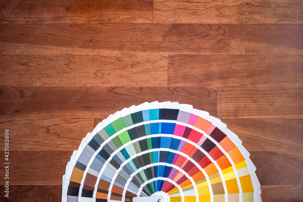 Fototapeta premium an open color swatch with all the different colors folded out on a wooden surface, cherry colored wood texture, horizontal