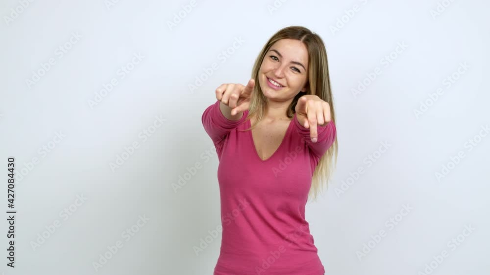 Young woman points finger at you with a confident expression over isolated background Young woman points finger at you with a confident expression over isolated background