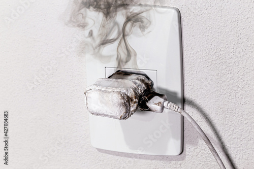 Fotografía cell phone charger short-circuited, smoke and fire, electrical appliance melting
