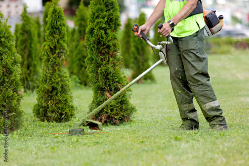 Man Gardener Worker Changing Landscape with String Lawn Trimmer