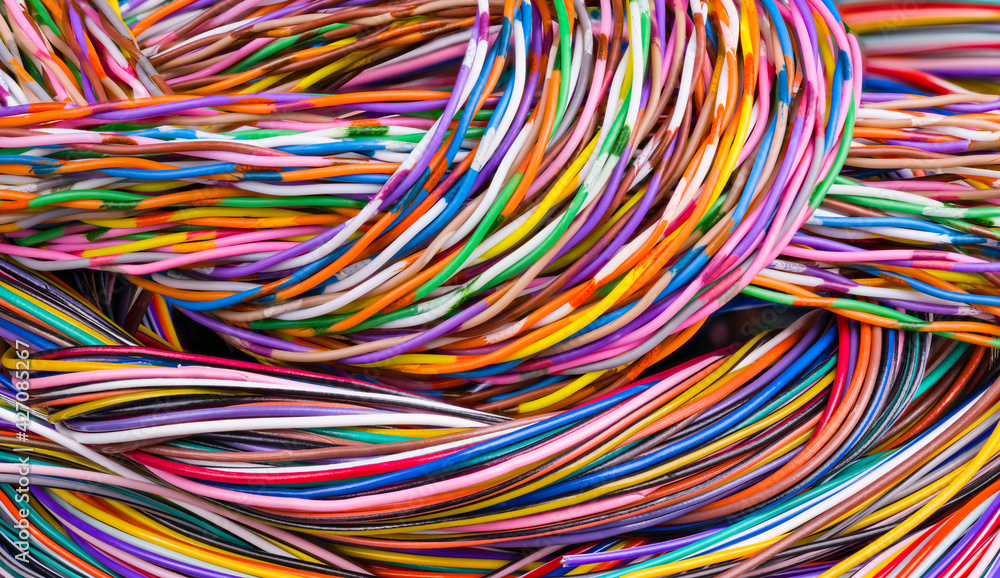 Colorful background of multicore cables bunch. Detail of wiring loom tangle. Closeup of beautiful braids from electric wires with plastic insulation in abstract colored texture. Electrotechnics. Tech.