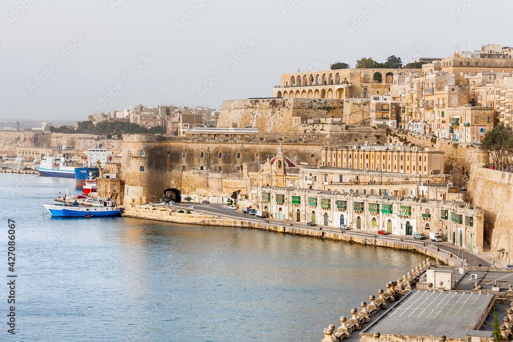 Panorama of Valletta, st.Barbara Bastion and fort Laskaris at early foggy morning. Architectural monuments on coast of Mediterranean sea in capital of Malta.