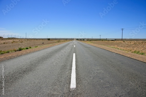 Hitchhiking along empty highway with no people in Keetmanshoop, Namibia.