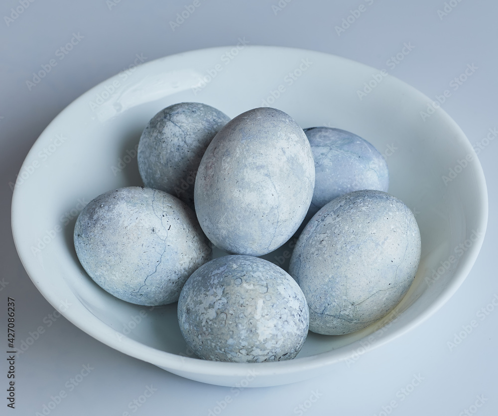 Eggs painted in blue and white are on a plate. Eggs painted in blue and white are on a plate.