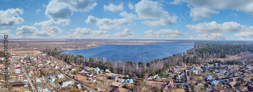 countryside with clowds above houses and lake