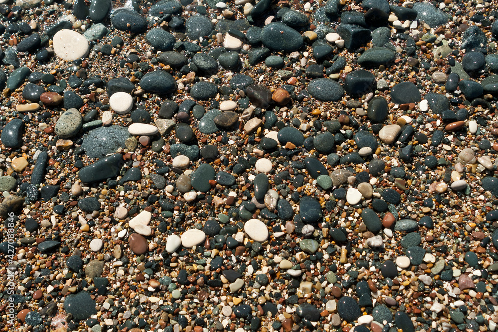 wet multi colored stones and pebbles on sea beach wet multi colored stones and pebbles on sea beach