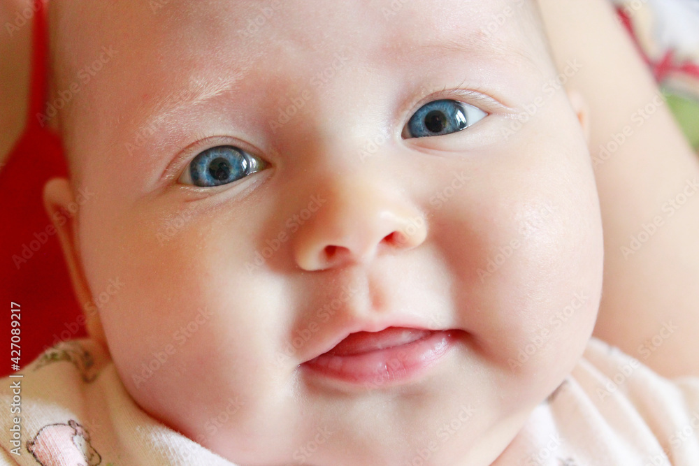 Face of smiling newborn baby lying on mother's arms Face of smiling newborn baby lying on mother's arms