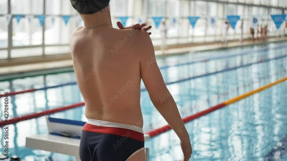 young swimmer teenager slaps himself on the shoulders before the
