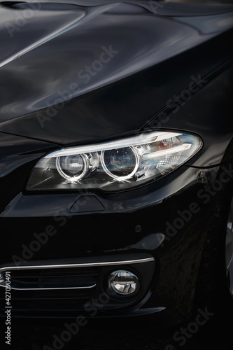 Vertical photo of car headlights close up.