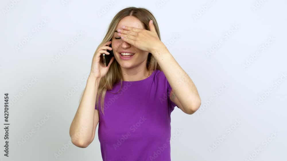 Young woman talking on mobile phone covering eyes by hands. Surprised to see what is ahead over isolated background Young woman talking on mobile phone covering eyes by hands. Surprised to see what is ahead over isolated background