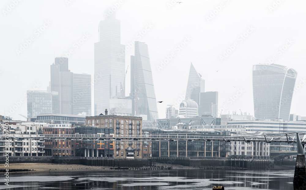 City of London financial district  in raining, misty day view from the River Thames. Empty streets of London during national lockdown UK, 2021