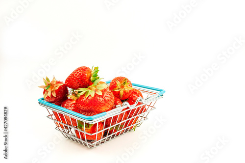 Grocery basket with strawberries on an isolated white background. The concept of online shopping on the internet fresh fruits and berries.