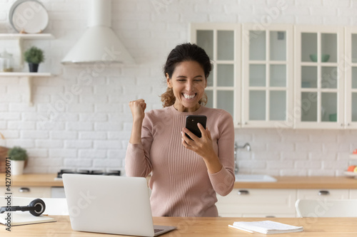 Картината върху платно Overjoyed hispanic woman student on distant learning receive text message on cell with good exam results