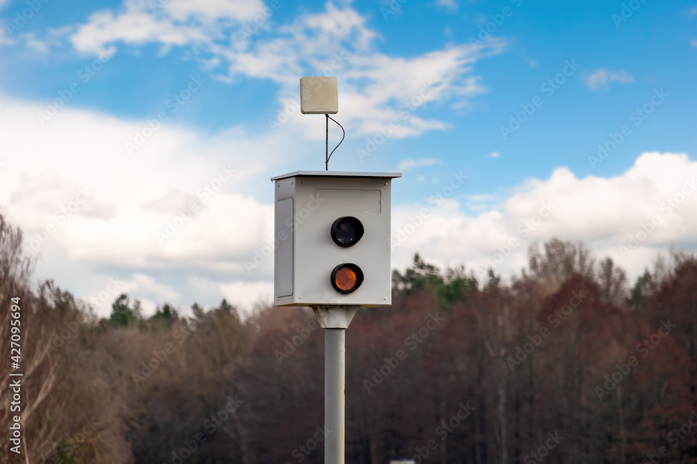 Speed camera for measuring speed of passing vehicles stands at countryside road. Speed camera for measuring speed of passing vehicles stands at countryside road.