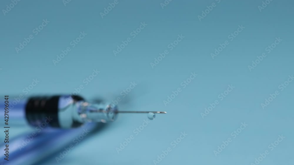 a syringe with medical supplies (vaccine) on blue background a syringe with medical supplies (vaccine) on blue background
