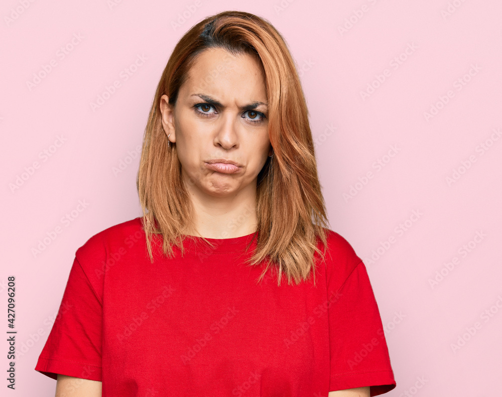 Hispanic young woman wearing casual red t shirt depressed and worry for distress, crying angry and afraid. sad expression. Hispanic young woman wearing casual red t shirt depressed and worry for distress, crying angry and afraid. sad expression.
