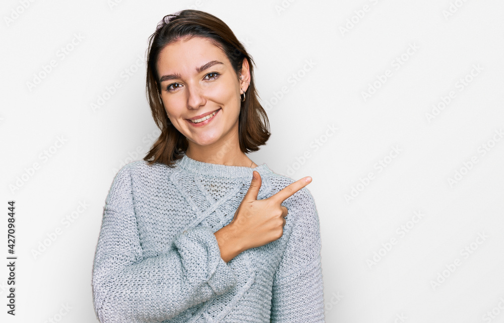 Young caucasian girl wearing casual clothes cheerful with a smile of face pointing with hand and finger up to the side with happy and natural expression on face Young caucasian girl wearing casual clothes cheerful with a smile of face pointing with hand and finger up to the side with happy and natural expression on face