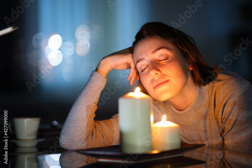 Obraz na płótnie Relaxed woman smelling aromatic candles in the night