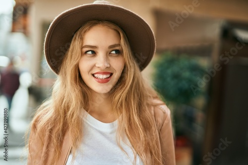 Young blonde girl smiling happy standing at the city.