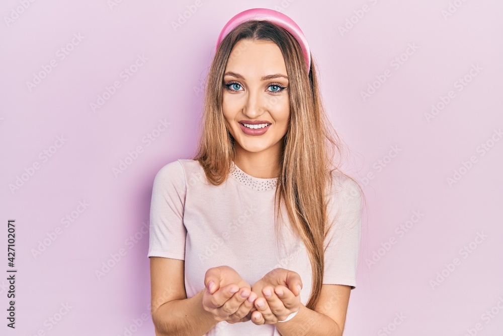 Young blonde girl wearing casual clothes smiling with hands palms together receiving or giving gesture. hold and protection Young blonde girl wearing casual clothes smiling with hands palms together receiving or giving gesture. hold and protection