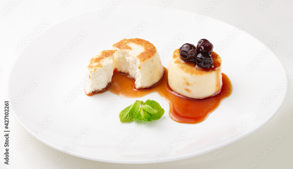 Cheesecakes on a plate with jam and berries on top Cheesecakes on a plate with jam and berries on top